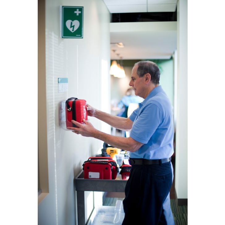 Image d'un technicien présentant et mettant en service un défibrillateur 